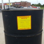 drum of hazardous waste in gas station parking lot