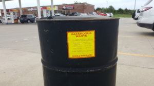 drum of hazardous waste in gas station parking lot