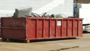 Open-top roll-off container holding scrap metal for recycling